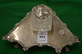 A silver inkstand with cut glass inkwell.