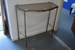 A glass and brass console table.