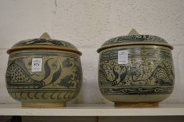 A matched pair of Asian blue and white porcelain jars and covers painted with fish and flora.
