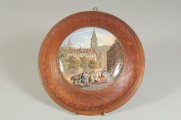 A PORCELAIN POT LID, A FRENCH STREET SCENE, 4.5ins diameter, framed.