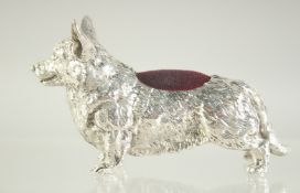 A LARGE NOVELTY WHITE METAL CORGI PIN CUSHION, 8cm long.