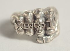 A SILVER RING WITH FIST AND SKULLS.