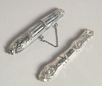 TWO SILVER NEEDLE CASES.