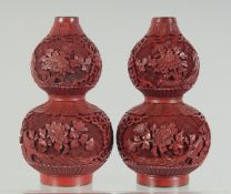 A PAIR OF CINNABAR LACQUER DOUBLE GOURD VASES, with panels of floral decoration and blue enamelled