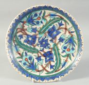 A 19TH CENTURY TURKISH KUTAHYA GLAZED POTTERY PLATE, 25.5cm diameter.
