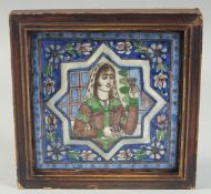 A FRAMED PERSIAN QAJAR GLAZED POTTERY TILE, central star portrait panel and foliate border, 20cm