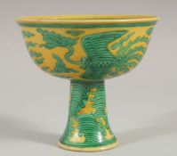 A CHINESE YELLOW GROUND STEM CUP - POSSIBLY 18TH CENTURY, with phoenix and stylised clouds, six-