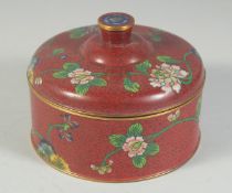 A CHINESE RED GROUND CLOISONNE CIRCULAR BOX AND COVER, decorated with flora, 12.5cm diameter.