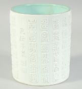 A CHINESE WHITE AND TURQUOISE GLAZE PORCELAIN BRUSH POT, with relief columns of characters, the base
