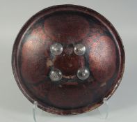 AN INDIAN PAINTED AND LACQUERED LEATHER DHAL SHIELD, 34cm diameter.