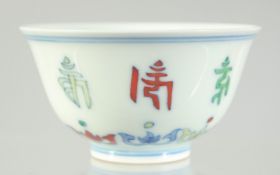A CHINESE DOUCAI PORCELAIN CUP, with characters and six-character mark to base, 8.5cm diameter.