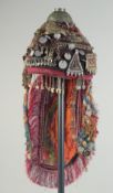 A TURKMEN CERAMONIAL HEAD DRESS, with various stone inset metal pieces and coins.