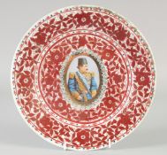 A QAJAR RED AND WHITE PORCELAIN PLATE, with central portrait medallion and foliate decoration, 26.
