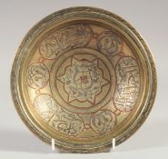 AN ISLAMIC SILVER AND COPPER INLAID BRASS DISH, 20.5cm diameter.