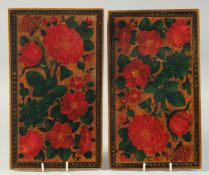 A PAIR OF PERSIAN LACQUER BOOK COVERS, painted with flowers, 28cm x 16cm.