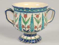 A 19TH CENTURY IZNIK STYLE TWIN HANDLE CUP, 9.5cm high.