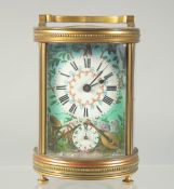 A 19TH CENTURY FRENCH BRASS CIRCULAR CARRIAGE CLOCK with enamel painted dial, raised trophies and