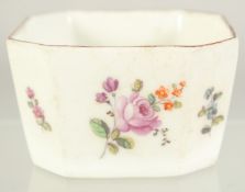 A CHELSEA PORCELAIN BUTTER PAT with canted corners and painted with flowers. 2ins.