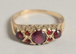 AN EDWARDIAN GOLD FIVE STONE RUBY RING.