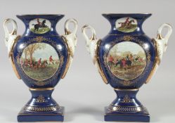 A PAIR OF CONTINENTAL BLUE TWO HANDLED HUNTING SCENE VASES. 11ins high.