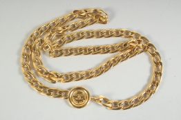 A LONG GILT METAL CHANEL CHAIN with medallions. 30ins long in a Chanel box.