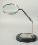 WATT & SONS LTD SILVERED MAGNIFYING GLASS on a stand.