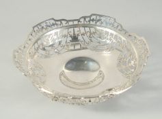 A PIERCED CIRCULAR SILVER FRUIT BOWL on three claw and ball feet. 9ins high, Birmingham 1935. Maker: