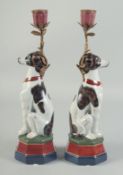 A PAIR OF SEATED PORCELAIN DOGS with candle sconces. 1ft 1ins high.