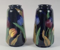 A PAIR OF ROYAL STANLEY WARE BLUE GROUP VASES painted with tulips. 10ins high.