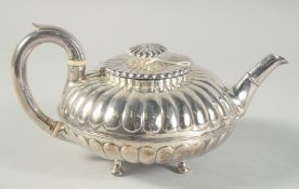 A GEORGE III SILVER CIRCULAR FLUTED TEA POT on three pad feet. London 1819. Maker Nathan & Hayes.