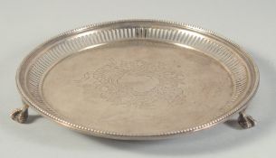 A VICTORIAN SILVER CIRCULAR SALVER with pierced and bead edge on three claw and ball feet. 7.5ins