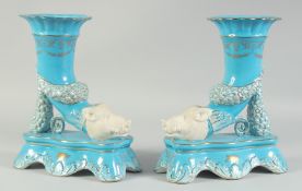 A PAIR OF PORCELAIN LIGHT BLUE BOARS HEAD SPILL VASES. 11ins high.