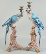 A GOOD PAIR OF BLUE PORCELAIN PARROT CANDLESTICKS on rustic bases, brass capped. 1ft 6ins high.
