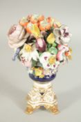 A GOOD DERBY FLOWER ENCRUSTED URN on a gilt base with claw feet. 7ins high.