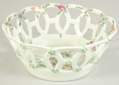A 1ST PERIOD WORCESTER PORCELAIN OVAL PIERCED BASKET painted with flowers. 6.5ins diameter.