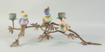 A RUSTIC BRONZE AND PORCELAIN PARAKEET CENTREPIECE with two candle sconces. 1ft 6ins long.