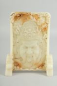 A CARVED CHINESE WHITE JADE SCREEN carved with a head. 9ins high.