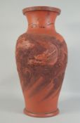 A LARGE CHINESE TERRA COTTA VASE carved with dragons and figures. 26ins high.