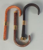 THREE SNAKESKIN COVERED WALKING STICK HANDLES. (3).