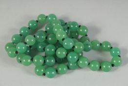 A STRING OF JADE BEADS 26ins long.