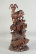 A SUPERB BLACK FOREST CARVING OF A PAIR OF MOUNTAIN GOATS one standing, the other seated on a