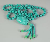 A STRING OF TURQUOISE BEADS plus pendant. 36ins long.