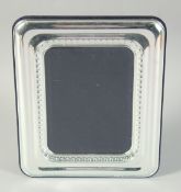 A PLAIN SILVER UPRIGHT PHOTOGRAPH FRAME. Photo size 6.75ins x 5Ins. London hallmark, modern.