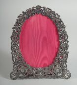 A VICTORIAN PIERCED SILVER EASEL PHOTOGRAPH FRAME with scrolls and flowers. 7ins x 5.5ins.