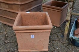 A pair of square shaped terracotta plant pots.