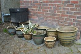 A quantity of glazed plant pots and a barrel shaped tub.