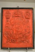 An Eastern relief moulded and red stained plaque.
