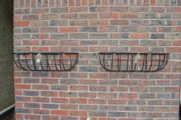 A pair of wrought iron wall planters.