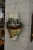 An unusual wall mirror with pierced and shaped glass frame.