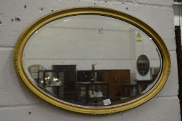 A gilt framed oval wall mirror.